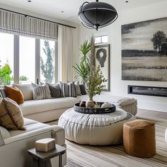 a living room filled with furniture and a large painting hanging on the wall above it