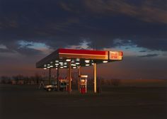 an empty gas station at dusk with the sky in the background