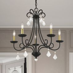 a chandelier hanging from the ceiling in a room with white walls and flooring