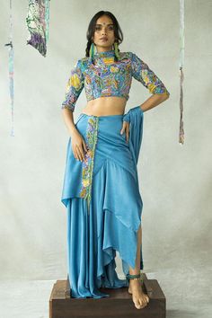 Denim blue cupro satin lehenga with multi-colored beaded hand embroidery and an asymmetric handkerchief hemline. Comes with an abstract printed blouse and a dupatta.
Components: 3
Pattern: Printed, Hand embroidered
Type Of Work: Abstract, Beads
Neckline: High Neck
Sleeve Type: Half
Fabric: Cupro satin
Color: Blue
Other Details: 
Closure:
Blouse: Concealed side zip and keyhole
Lehenga: Concealed side zip
Note: Jewellery and accessories worn by the model are not for sale.
Disclaimer: Slight differ Tassel Embroidery, Satin Lehenga, Blouse Lehenga, Hand Embroidered Blouse, Beaded Skirt, Beaded Neckline, Satin Color, Fabric Beads, Satin Blouse