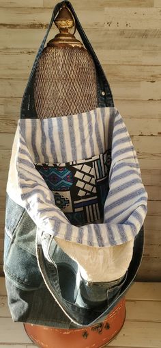 an old purse sitting on top of a wooden table next to a pair of jeans