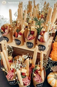 a table topped with lots of different types of sandwiches and dips next to pumpkins