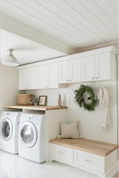 a washer and dryer sitting in a room next to a counter with wreaths on it