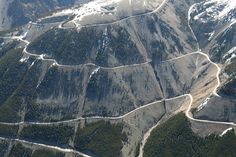 an aerial view of mountains and roads in the snow covered hills are seen from above