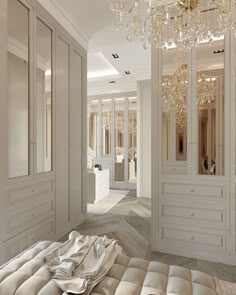 an elegant bedroom with chandelier and dressing room in the backround area