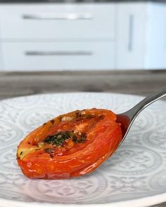 a spoon with some food on it sitting on a plate