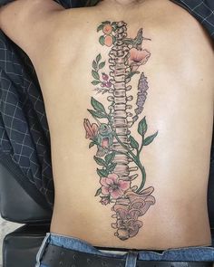 a woman's back with a skeleton and flowers on it