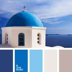 a blue and white church with the ocean in the background