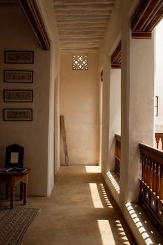 the sun shines through two windows in an old building with wooden railings and benches