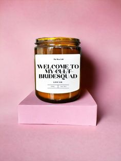 a candle that is sitting on top of a pink block with the words welcome to my cute bridesmaad