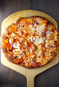 a pizza sitting on top of a cutting board covered in cheese and onion toppings