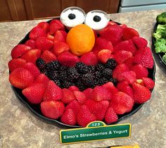 a plate with strawberries and berries in the shape of an elmo's face