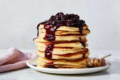 a stack of pancakes covered in blueberry syrup