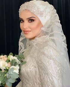 a woman wearing a veil and holding a bouquet