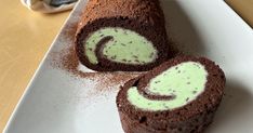 there is a chocolate roll with green icing on the top and two slices cut out