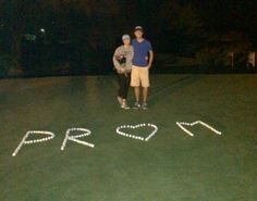 two people standing in front of the word prosper written with white lights on grass