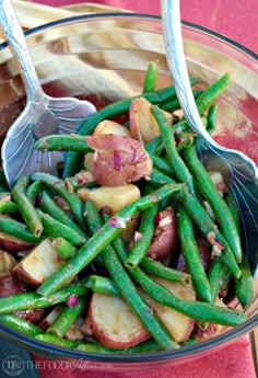 a glass bowl filled with green beans and potatoes