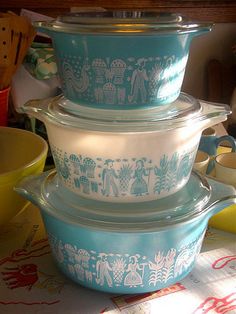 three blue and white dishes stacked on top of each other in front of a table