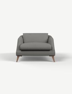 a gray couch sitting on top of a white floor next to a wooden leg chair