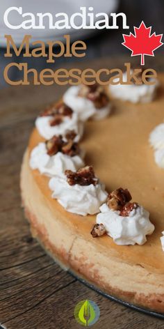 a cheesecake topped with whipped cream and walnuts on a wooden table next to a canadian maple leaf