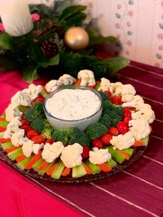 a platter with broccoli, cauliflower and carrots on it