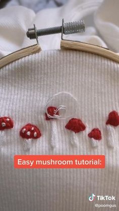 an embroidery project with red mushrooms on it