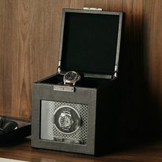 a watch in a black box sitting on a shelf