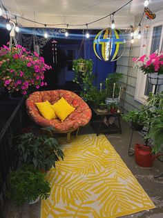 a yellow and red couch sitting on top of a rug next to potted plants