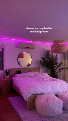 there is a bed with white pillows and pink lights on the wall in this bedroom