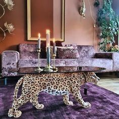 a leopard figurine sitting on top of a table in front of a couch