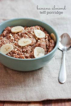 a bowl of oatmeal with banana slices and nuts in it next to a spoon