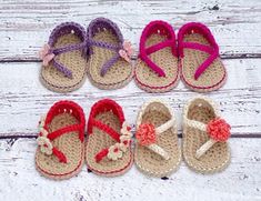 crocheted baby sandals with bows on them are lined up against a white wooden background