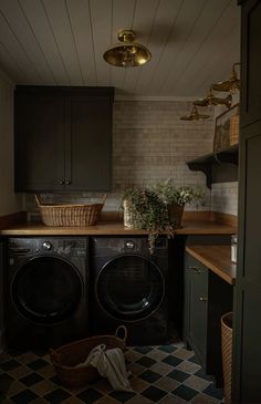 a washer and dryer sitting in a room next to a counter with baskets on it