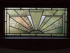 a close up of a stained glass window in a room with dark walls and flooring