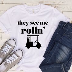 They See Me Roll'n Shirt, Golf Shirt, Golfing T-Shirts, Golfing Party Tee, Golf Shirt, Golfer Apparel, Sports, Golf Lover Shirt Gift This classic unisex jersey short sleeve tee fits like a well-loved favorite. Soft cotton and quality print make users fall in love with it over and over again. These t-shirts have-ribbed knit collars to bolster shaping. The shoulders have taping for better fit over time. Dual side seams hold the garment's shape for longer.  --------PRODUCT INFORMATION -------- .: 1 Team Spirit T-shirt With Team Name For Golf, Crew Neck T-shirt With Team Name For Golf, Team Spirit Cotton T-shirt For Golf, Golf T-shirt With Graphic Print For Team Spirit, White Golf Tops With Sublimation Print, White Golf T-shirt With Team Name, White Golf Shirt With Graphic Print, White Graphic Print Shirt For Golf, White Crew Neck Golf Top