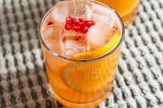 two glasses filled with orange juice and garnished with pomegranates