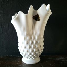 a white vase sitting on top of a table