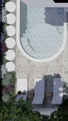 an aerial view of two lounge chairs next to a swimming pool in the middle of a garden