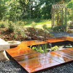 an outdoor pond surrounded by rocks and plants