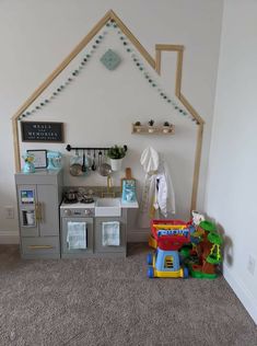 a play room with toys and decorations on the floor in front of a white wall