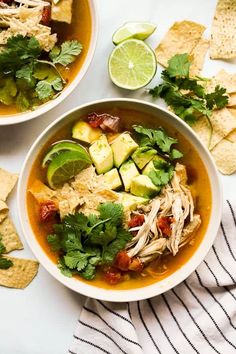 two bowls of chicken tortilla soup with avocado and cilantro