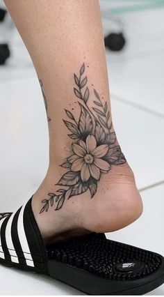 a woman's foot with a flower tattoo on it