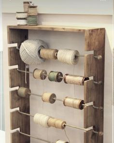 an old wooden rack holds several spools of thread