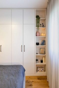 a bed sitting next to a white book shelf