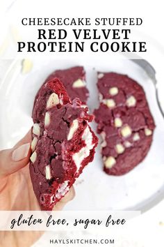 red velvet protein cookie with cheesecake filling is shown on a white plate and has been cut in half