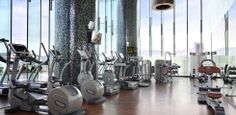 there are many treadmills in the gym with glass walls and floor to ceiling windows