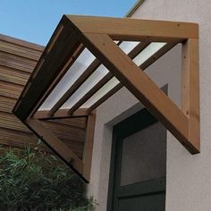 an open window on the side of a house with wood slats and green doors