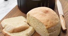 a loaf of bread sitting on top of a cutting board next to an air fryer