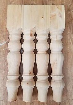 four white wooden posts are lined up against each other on a wood flooring board