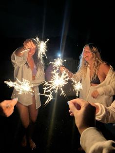 two women are holding sparklers in their hands